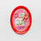pink and red oval trinket tray with white cat and says 'portrait of a perfect little friend' with jewelry inside