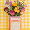 pink word search puzzle book shaped ceramic vase on a yellow gingham background