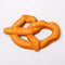 side view of smooshed soft pretzel shaped de-stress ball with white heart shaped 'salt' on top
