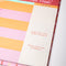 up close of colorful 'take notes this week' desk planner with stand