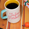 ceramic mug with paper lines and pink cursive 'infinite potenial' typography across the front and light blue handle with coffee inside