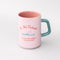 top view of light pink ceramic mug with teal handle and 'do not disturb! i am currently reading a really good book!' typography on both sides