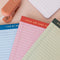 set of three ini legal pads: red/pink with 'these are some serious notes' on the top, green with 'don't forget! write it down!' and blue with 'i did my best' laid flat on a table fanned on a table