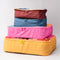 side view of colorful packing cubes: burgundy, blue, pink and golden yellow