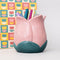 light pink tulip shaped pencil holder with pens inside and in front of a notebook