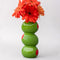 Ceramic vase with sculpted olive design inspired by classic martinis, styled with flowers on a bar cart.