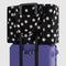 black cloud carry-on bag with white polka dot print on a suitcase