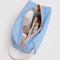 light blue dopp kit with orange zipper with items inside