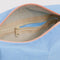 interior pouch of light blue dopp kit with orange zipper