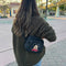 model carrying black fanny pack with embroidered mickey head and red 'MICKEY' font