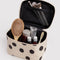 cream large cosmetic case with black polka dots with items inside