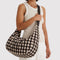 model carrying brown blurred gingham large nylon crescent bag