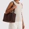 model carrying dark brown medium bowler bag