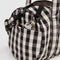 side view of black and white gingham nylon duffle bag