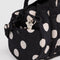 side view of black duffle bag with cream polka dots