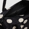 black interior of black duffle bag with cream polka dots