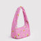 side view of bright pink small meringue bag with gold melting star print and thick twist strap