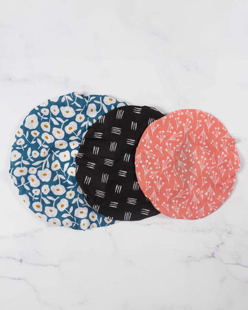 set of three reusable bowl covers. large: blue and white floral, medium: black and white lines, and small: pink and white dainty floral