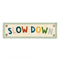 beige canvas banner with colorful 'SLOW DOWN' and sage green trim