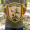 model holding yellow, green and pink embroidered banner with wildflowers and 'wild at heart' across the top