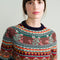 up close of model wearing navy sweater with colorful fair isle print on the top half