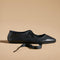 side view of black ballet inspired flats with tie laces and pointed toe