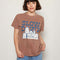 model wearing brown relaxed tee with snoopy graphic 'slow down and take care' typography