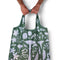 model holding green reusable bag with mushroom and nature print