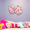 pink heart dice rug with purple border hanging on wall
