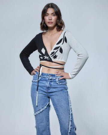model wearing black and white split crop top with vine print and tie wraparound bottom