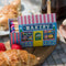colorful bakery shaped box with pink, blue and white tipped matches inside
