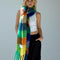 model with tied multicolored oversized checkered scarf with fringe around their neck