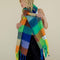 model wearing multicolored oversized checkered scarf with fringe