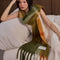 model wearing thick scarf with orange, burnt red, and moss green print and fringe
