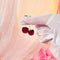 model holding gold cherry dangle earrings