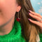 model wearing gold cherry dangle earrings