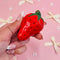 model holding small strawberry shaped incense holder