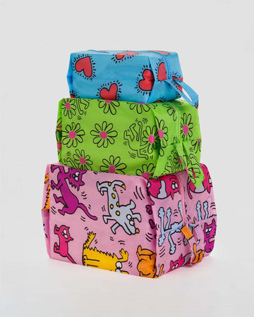 set of three keith haring print zip pouches: small blue hearts, medium green flowers, and large pink pets