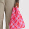 model holding pink plaid baby baggu with all over star print