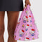 model carrying pink baby baggu with hello kitty and yellow tulips