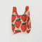 baby baggu in blush pink with large red strawberry pattern