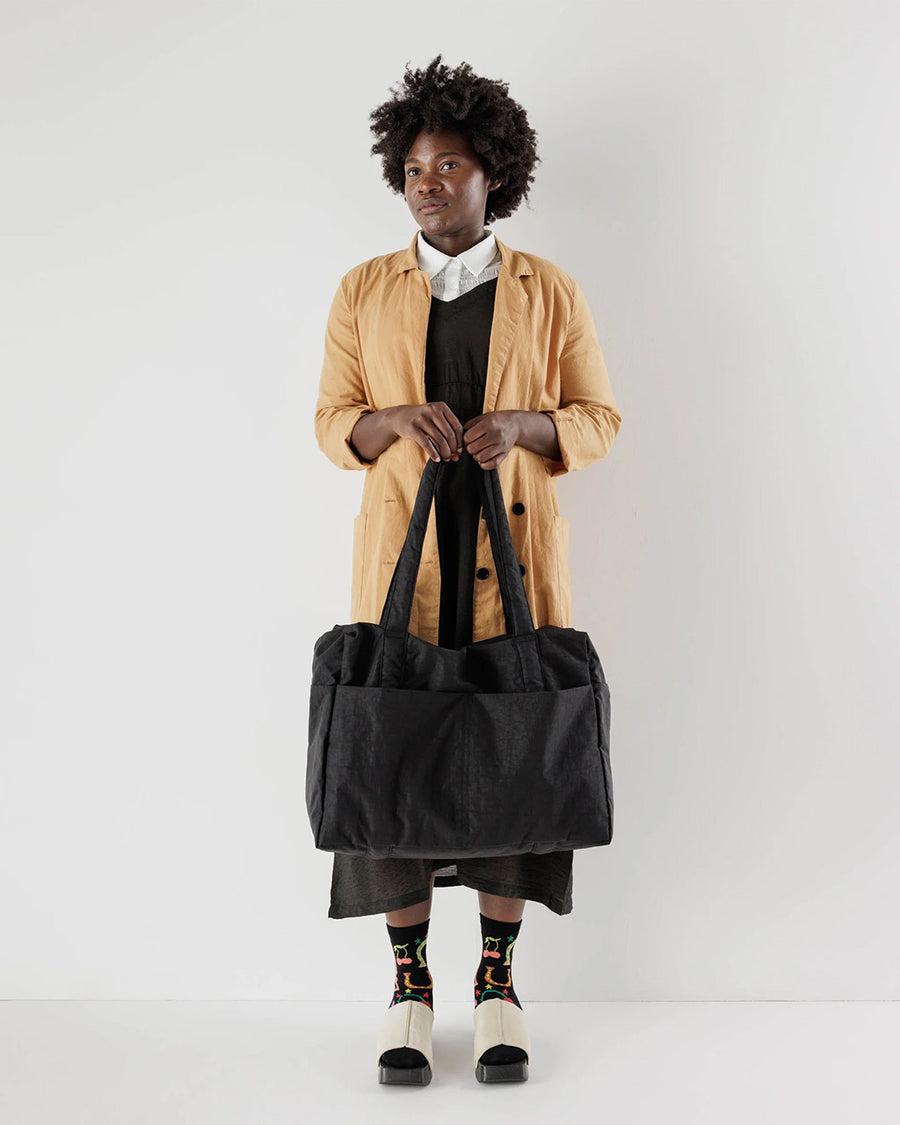 model holding black cloud carry on bag