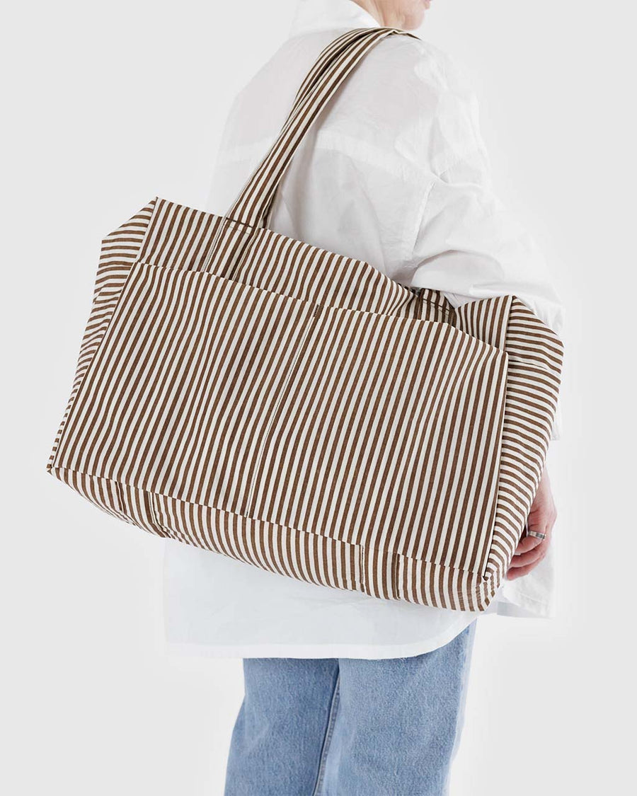 model carrying two tone brown vertical stripe cloud carry-on bag