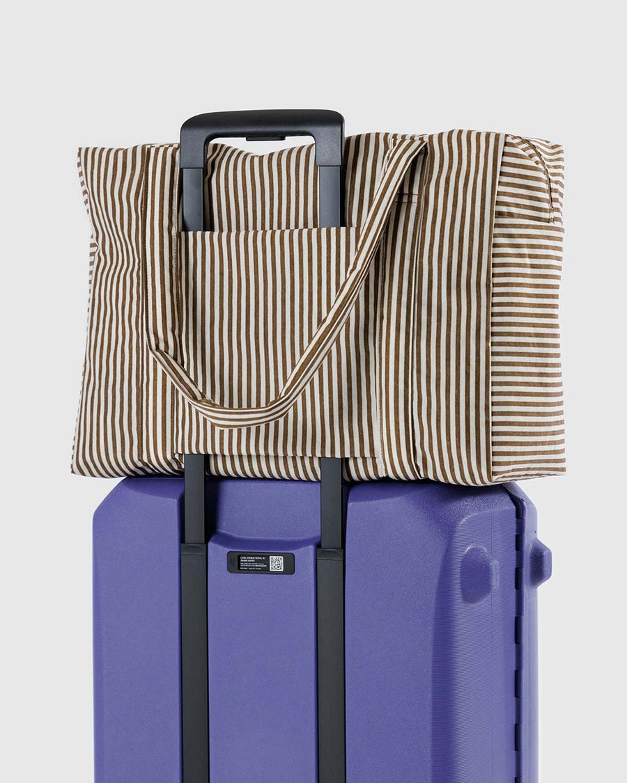 two tone brown vertical stripe cloud carry-on bag on a suitcase