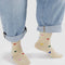 model wearing tan crew socks with colorful heart print design