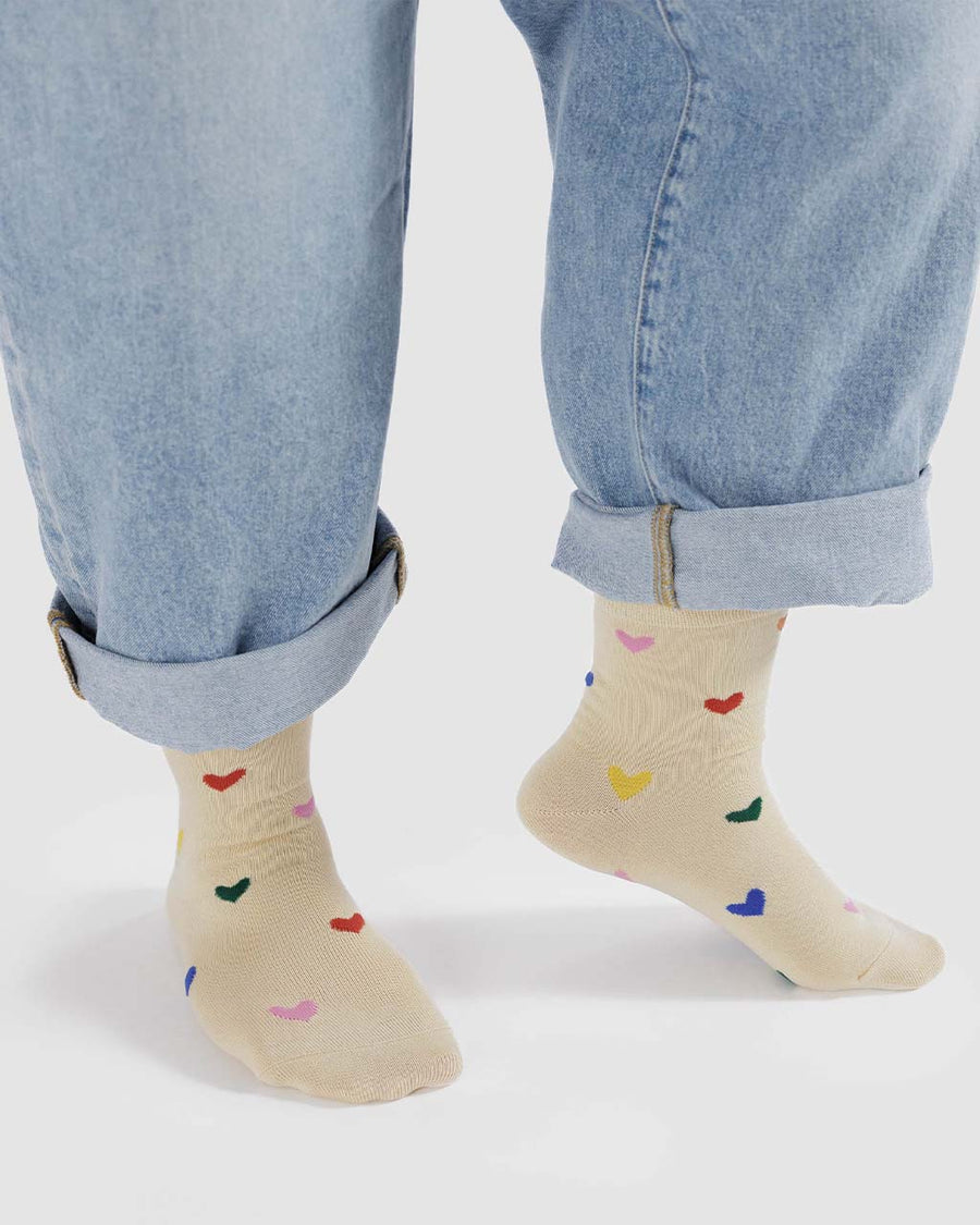 model wearing tan crew socks with colorful heart print design