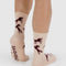 back view of model wearing cream crew socks with brown horse silhouette print