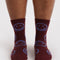 model wearing mahogany crew socks with lilac smiley faces