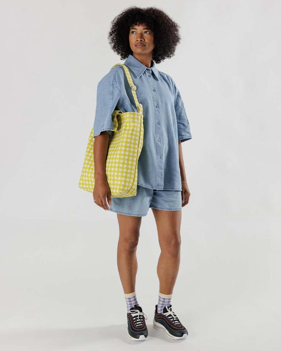 model carrying chartreuse and white pixel gingham duck bag