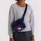 model wearing navy fanny pack with embroidered hello kitty with a milkshake and fishbowl as a crossbody